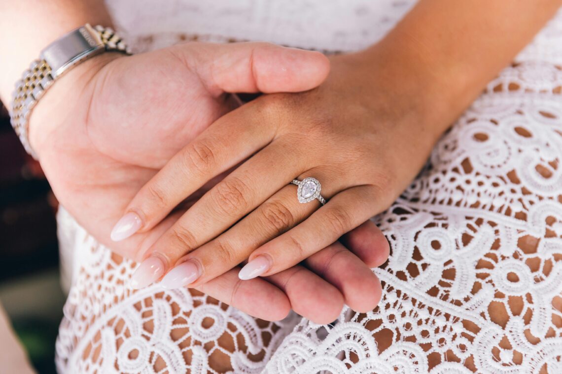 Close-up of a couple's hands, featuring a diamond engagement ring, symbolizing love.