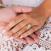 Close-up of a couple's hands, featuring a diamond engagement ring, symbolizing love.